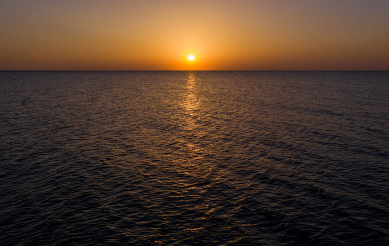 Sea sunrise early morning. Aerial View. Black Sea Sunset. Orange sky and low tide. Sea waves in the rays of a sunset. Sunset on the beach in summer season. Seascape. Sun over the skyline and sea waves