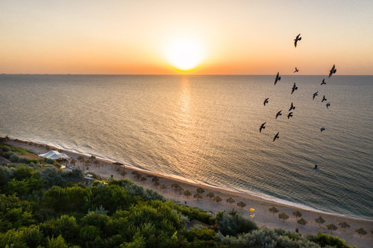 Sea sunrise early morning. Aerial View. Black Sea Sunset. Orange sky and low tide. Sea waves in the rays of a sunset. Sunset on the beach in summer season. Seascape. Sun over the skyline and sea waves