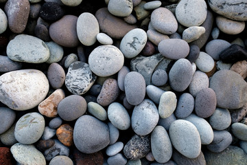 Pebbles and stones, various sizes and shapes, various minerals, close view.