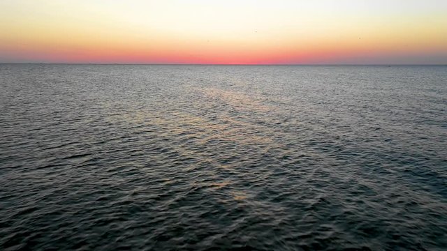 Sea sunrise early morning. Aerial View. Black Sea Sunset. Orange sky and low tide. Sea waves in the rays of a sunset. Sunset on the beach in summer season. Seascape. Sun over the skyline and sea waves