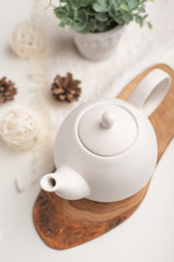 Ceramic white teapot with accessories on a white table, horizontal frame, tea time, tea drinking, retual tea making