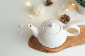 Ceramic white teapot with accessories on a white table, horizontal frame, tea time, tea drinking, retual tea making