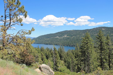 Blue lake with mountains in the background and trees in the foreground
