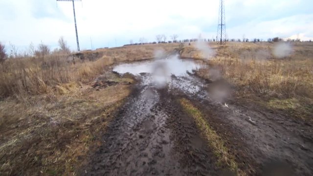 video through an off-road car windshield from inside the car. Driving old-fashioned off-road. video shaking car rides through a deep muddy puddle in the forest