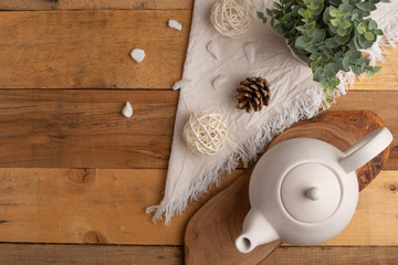 Fototapeta na wymiar Ceramic white teapot with accessories on a wooden table, horizontal frame, tea time, tea drinking, retual tea making