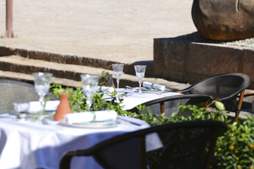 Restaurant terrace with dressed table in the sun and flower reflection