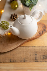 Fototapeta na wymiar Ceramic white teapot with accessories on a wooden table, vertical frame, tea time, tea drinking, retual tea making