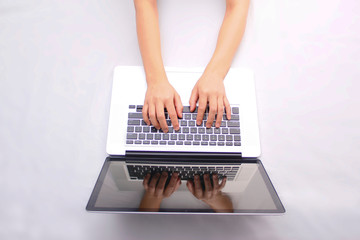 Fototapeta na wymiar Woman typing on a laptop on a white background