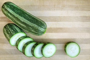 Raw sliced zucchini on a cutting board. Closeup, top view