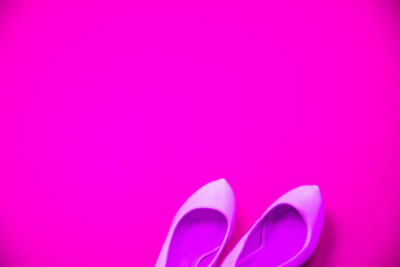 Pink high heeled shoes pink purple background - top view - heels pointing right