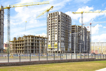  Construction site with cranes and building with blue sky  and clouds 