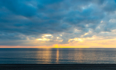 Fototapeta premium Picturesque sunset over Tyrrhenian Sea in Milazzo town, Sicily, Italy. Aeolian Islands (Italian: Isole Eolie), volcanic archipelago on the north of Sicily on the background