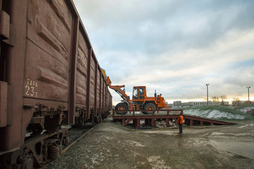 Fototapeta premium Loader are loading cullet in railway container.