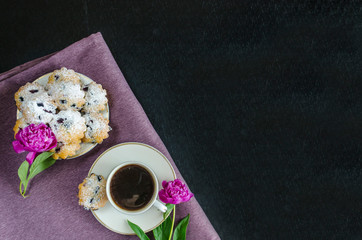 coffee with a cupcake and flowers. good morning! blueberry muffins and americano on a purple and black background. Espresso with baking. pink peonies in a stylish decor. copy space