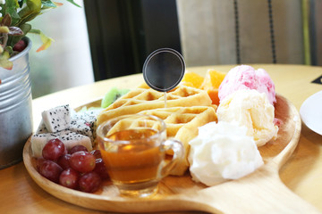 waffles with fruit and ice cream on wood plate