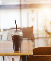Black coffee with ice on table in cafe.