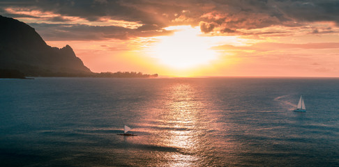 Sailboats sailing during sunset off the coast of Kauai Hawaii