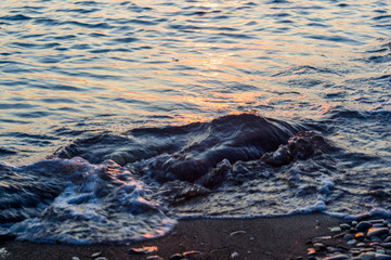 Obraz premium pebble stones on the sea beach, the rolling waves of the sea with foam