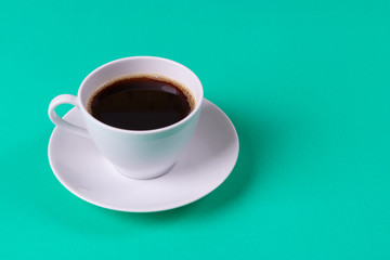 Black Coffee on pastel green table background. Copy space for text.
