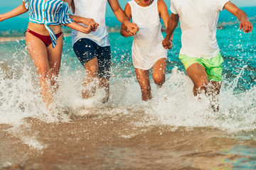 Fototapeta premium Friends running in the sea water and having fun