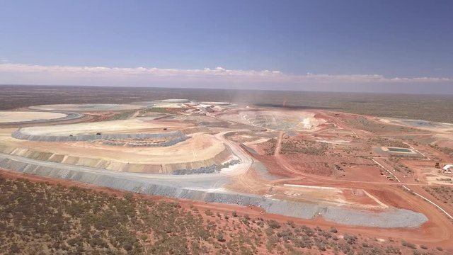 The gigantic mine Kalgoorlie extends to the horizon. Aerial view of the canyon-like mine with its huge trucks in the south west of australia
