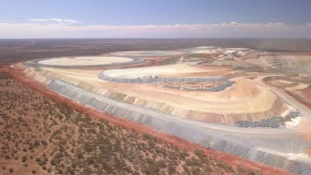 The gigantic mine Kalgoorlie extends to the horizon. Aerial view of the canyon-like mine with its huge trucks in the south west of australia