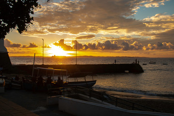 Sunset on the beach, with silhouettes of people at the seaside