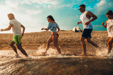 Group of cheerful people having beach party and dancing