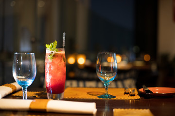 Red Juicy Fruit refreshment in high Glass with straw tube with ice and topping decoration for customer, Fresh smoothies Juice from natural to make diet good health for Dinner table with wine glasses