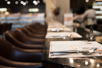 Empty room nobody Classic style of Restaurant with wooden table leather high chair with fork knife spot low light, interior design with calm and business discussion talk or private dinner couple