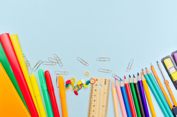 Colorful  school suplies against light blue background with copy space. Back to school concept, top view.