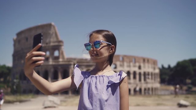 Little girl making selfie background Colosseum, Rome, Italy.