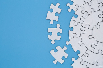 Unfinished white jigsaw puzzle pieces on blue background, The last piece of jigsaw puzzle, Copy...