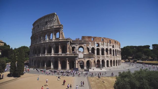 The Colosseum or Coliseum, Rome, Italy, time lapse of sight in summer day at clear sky background. People walk and take pictures
