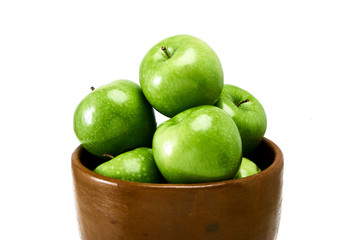 A group of Green Granny Smith cooking apples in a brown bowl isolated against a white background.