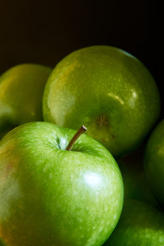 A close-up image of a group of green Granny Smith cooking apples.