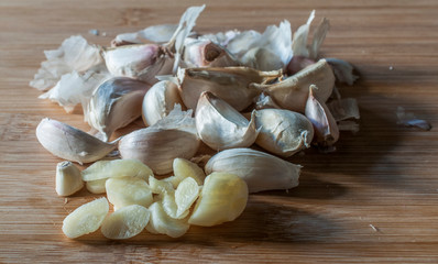 peeled garlic on a wooden cutting board