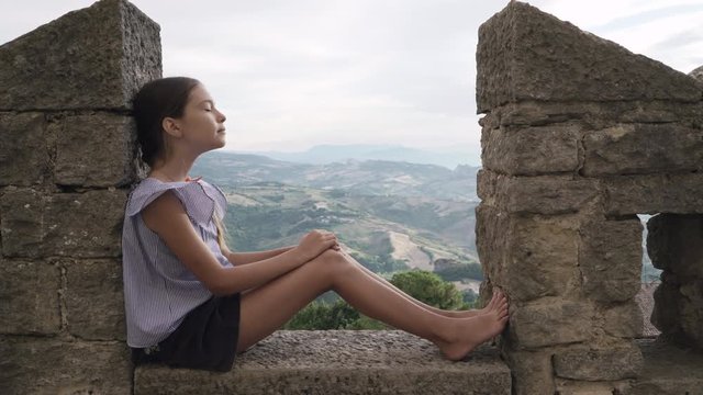 Little girl child relax on the background of the mountains. San Marino, Italy