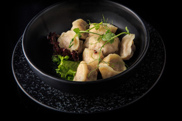 appetizing ready meat dumplings with salad in deep bowl