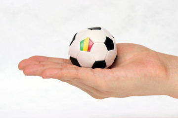 Mini football in hand and one black point of football is Mali flag on white background.