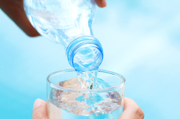 Healthy lifestyle Pour pure water from a bottle of mineral water into a glass.Health concept