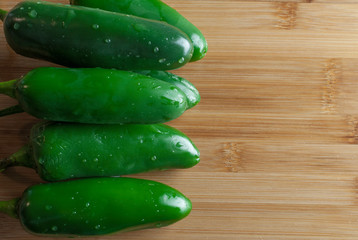 Frersh Jalapeño chiles on a wooden cutting board