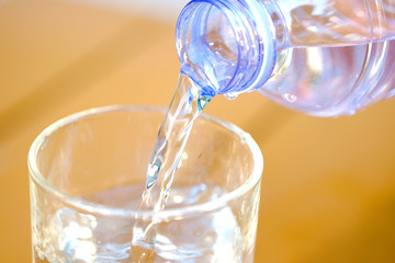 Healthy lifestyle Pour pure water from a bottle of mineral water into a glass.Health concept