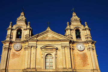 Fototapeta na wymiar Detail shot from ancient old church exterior in historic district of malta city over blue sunny sky in Mediterranean island Malta