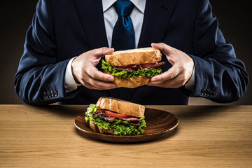 サンドイッチを食べるビジネスマン