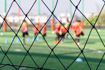 Close up Fence blurred image for background of kids are playing soccer football.