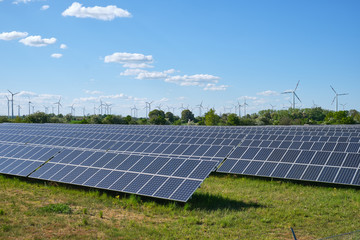 Modern solar panels with wind turbines in the back seen in Germany