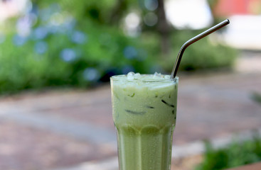 Iced green tea in crystal glass with stainless steel straw for drink.  Concept for reduce plastic pollution and support green eco friendly products.