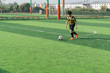 Asian Boy Training Football on the Pitch. Soccer Football Training Session for Kid