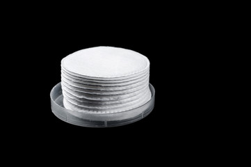 White round sponge for face care on a black background, isolate